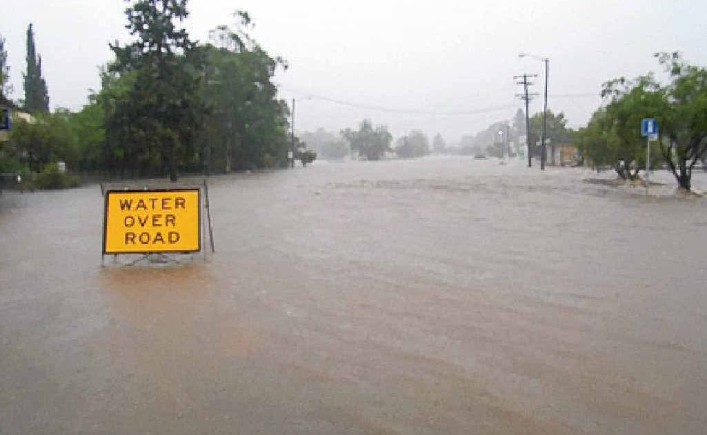 Floodwaters rush through Moore St, Goomeri diagonally opposite the police station police station. Floodwaters rush through Moore St, Goomeri diagonally opposite the police station police station.